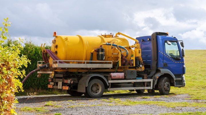 Septic pump truck with vacuum tank parked on site