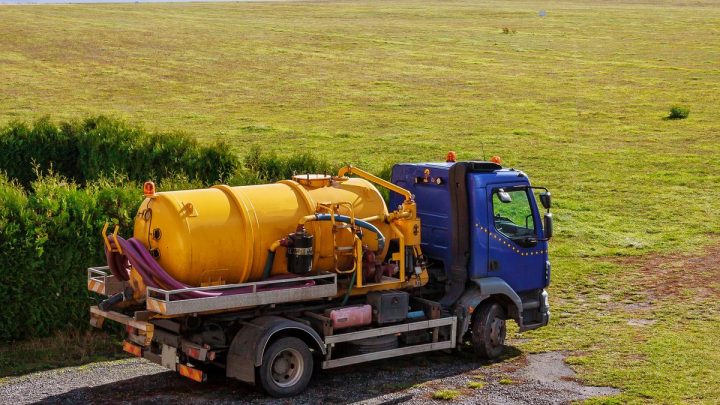 Sewage vacuum tanker truck, side view of tank and hoses