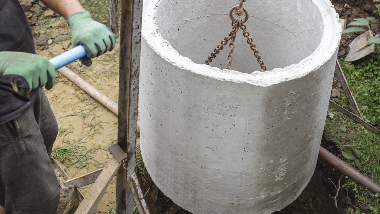 Concrete rings being laid underground for a rural house septic well