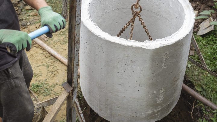 Concrete rings being laid underground for a rural house septic well