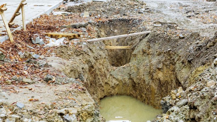 Sanitary sewer manhole being replaced in an excavated road opening