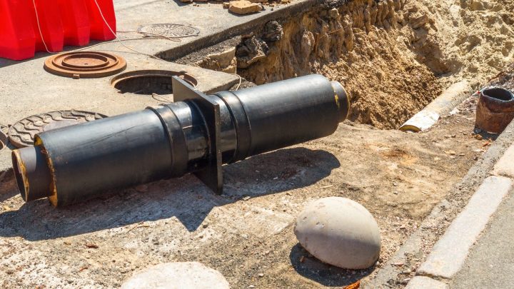Plumbing pipes sitting in an open ground pit during repair work