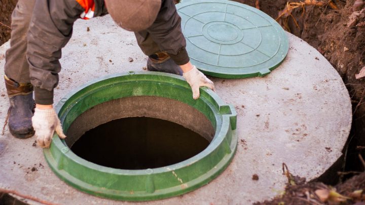 Builder installing the manhole on a concrete sewer well at a house