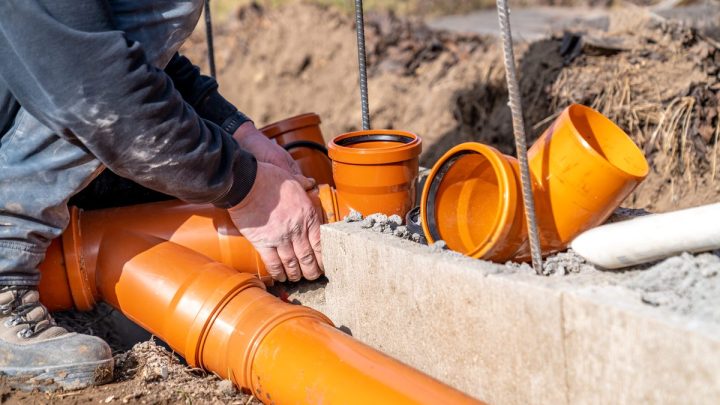 PVC sewer pipe laid in an open trench in bare earth