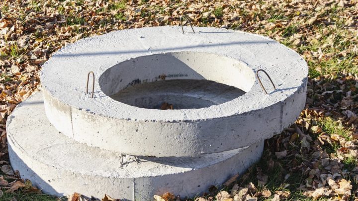 Stacked reinforced concrete well and sewer rings staged on site