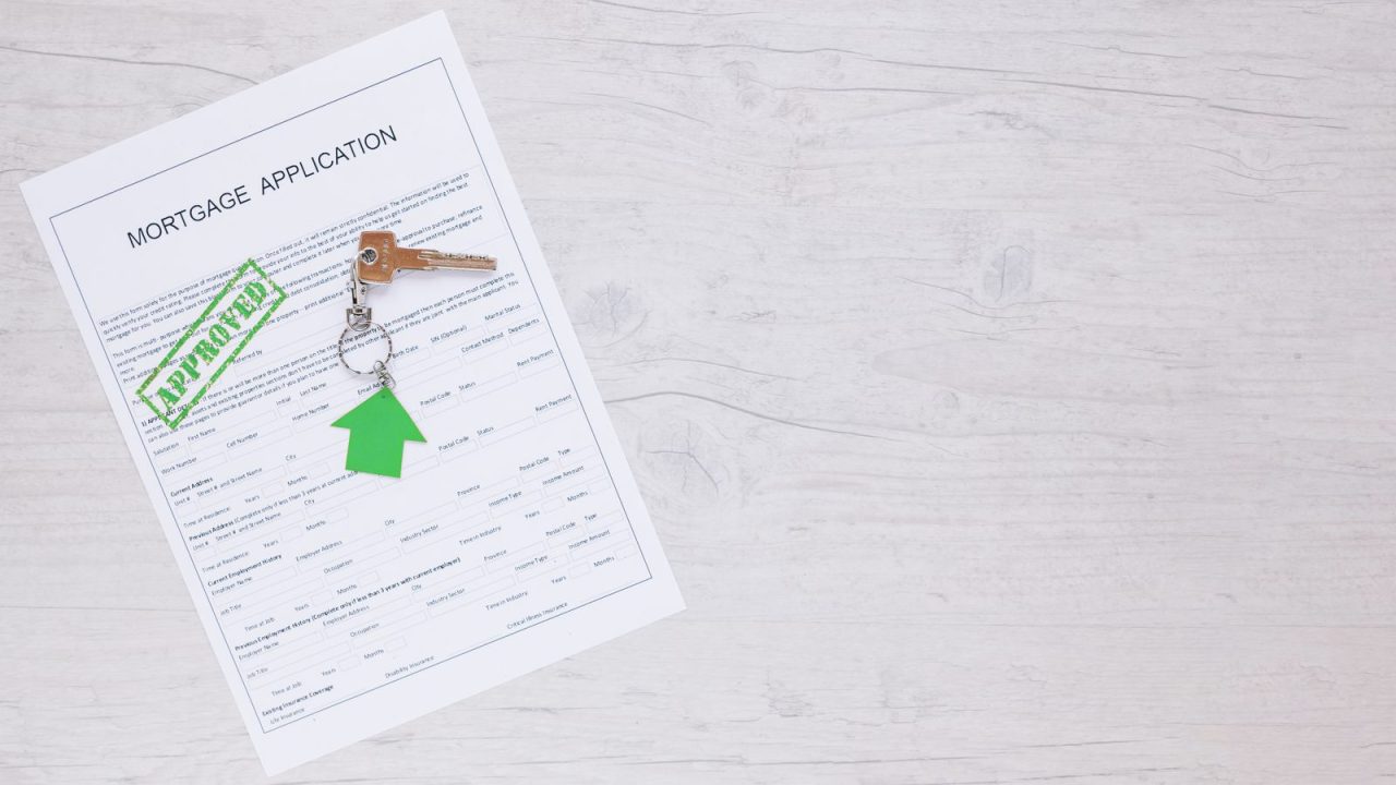 Approved-stamped form lying next to a house key, permit-approval look