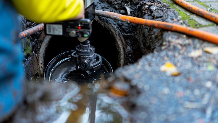Drain technician camera-inspecting a clogged line before clearing it