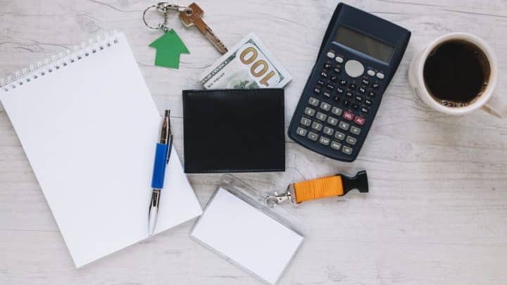 Desk flat lay with house keys, calculator and property contract papers