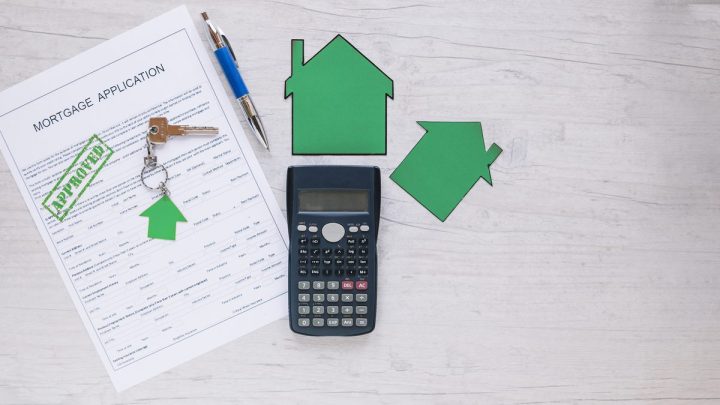 Property paperwork and a house key laid out on a desk