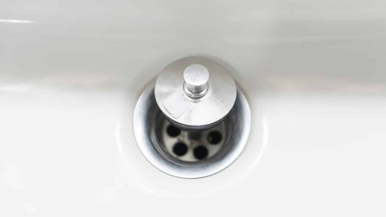 Extreme close-up of a washbasin drain hole and stopper