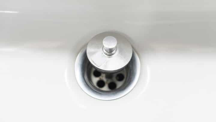 Extreme close-up of a washbasin drain hole and stopper