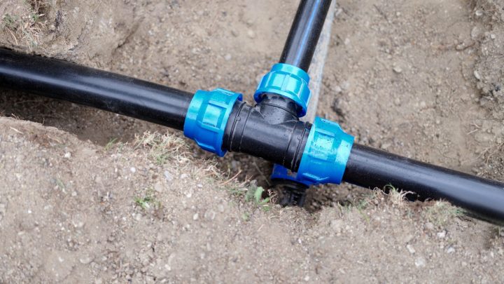 White PVC sewer pipe assembled and laid in an open dirt trench
